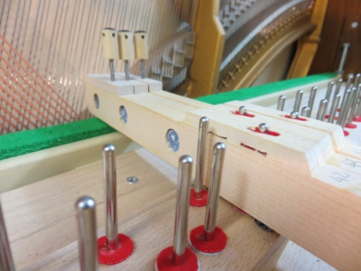 Piano droit, pointes de balancier et mortaises (trous garnis de feutre dans les touches de bois) de balancier.